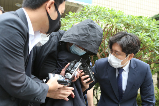 부산 해운대에서 '마약 질주'를 벌인 운전자가 18일 오전 부산지법 동부지원에서 구속 전 피의자 심문(영장실질심사)을 받고 난뒤 모습을 드러내자 취재진이 질문을 하고 있다.   연합뉴스